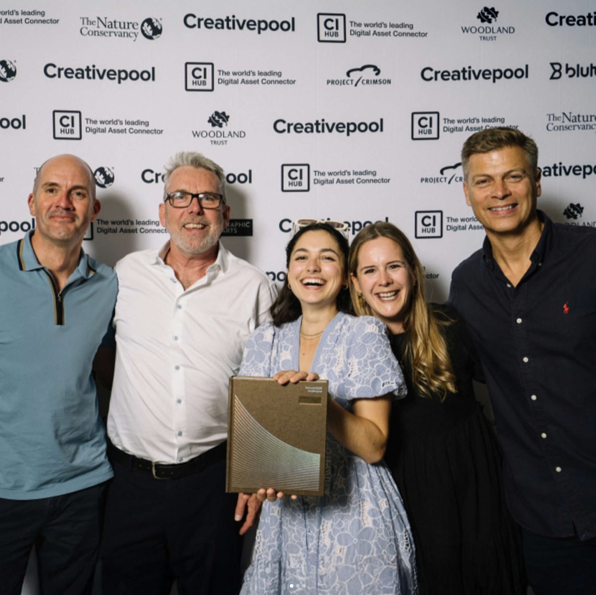 Group photo of the Mammal team and client team smiling at an awards event backdrop, the Creative Pool 2025, while holding a trophy